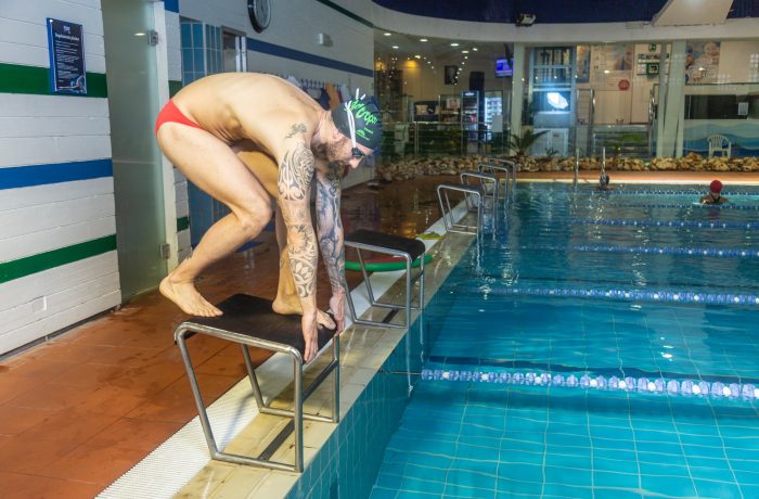 istruttore su blocco di partenza nella piscina tropos firenze